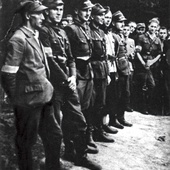 Grupa żołnierzy batalionu partyzanckiego Okręgu Śląskiego AK „Surowiec”. Trzeci od lewej dowódca batalionu por. Gerard Woźnica „Hardy”.  Lipiec 1944 r.