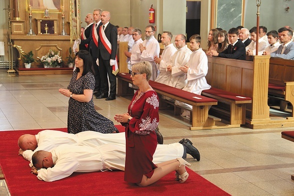 Święcenia diakonatu Bartosza Kaczmarczyka i Krzysztofa Kurpanika w kościele św. Andrzeja Boboli w Leszczynach, w archidiecezji katowickiej. Obok przyjmujących święcenia klęczą ich żony.