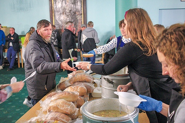 Wolontariusze Domu Nadziei rozdają jedzenie w auli seminaryjnej.