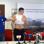 Pacjent prezentuje urządzenie stale monitorujące pracę jego serca i gotowe w każdej chwili reagować. Z lewej: Jarosław Kosior, z prawej - Cezary Orczykowski.