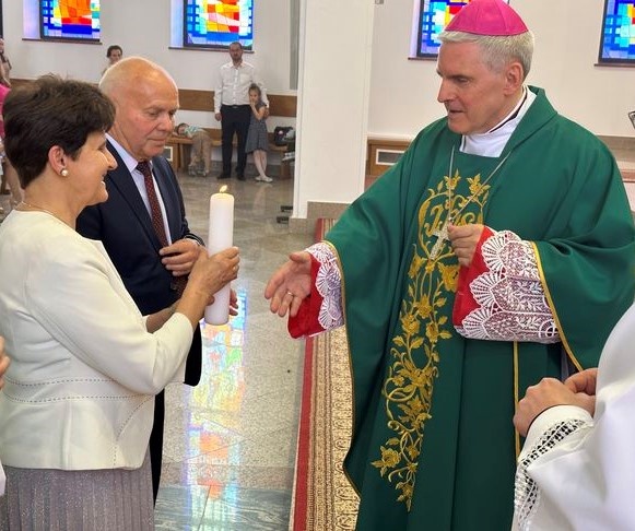 Bp K. Nitkiewcz wręcza świecę parze z Domowego Kościoła.