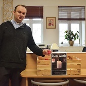Ks. Andrzej Wiecki prezentuje skrzynkę do woskowego recyklingu.