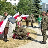▲	Kwiaty przed tablicą składają przedstawiciele wojska.