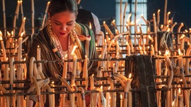 Kobieta zapala świece w sanktuarium Matki Boskiej el Rocío de Huelva w Andaluzji. 28.05.2023 Almonte, Hiszpania