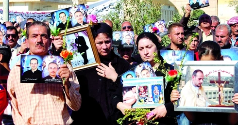 Katolicy z Bagdadu z fotografiami osób zamordowanych podczas krwawego ataku w czasie Mszy św.  w katedrze 1 listopada 2010 r.