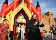 Ks. Krzysztof Kowal przed dmuchanym kościółkiem