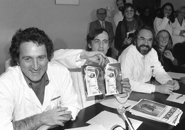 Jacques Testart (w środku) pokazuje zdjęcia Amandine – pierwszego we Francji dziecka z probówki (rok 1982).