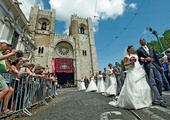  12.06.2012. Lizbona. Portugalia. Młodzi małżonkowie opuszczają katedrę.  Częścią obchodów ku czci św. Antoniego, urodzonego w Lizbonie patrona małżonków,  są śluby wielu par jednocześnie. W tym roku w związek małżeński wstąpiło ich 16.