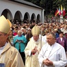 Cztery flagi widoczne nad wejściem do sanktuarium. Pośrodku kard. Meisner