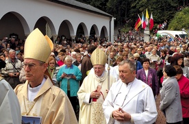 Cztery flagi widoczne nad wejściem do sanktuarium. Pośrodku kard. Meisner