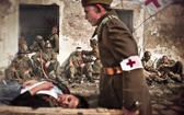  Żołnierz 10. Pułku Piechoty wynosi ranną kobietę  
