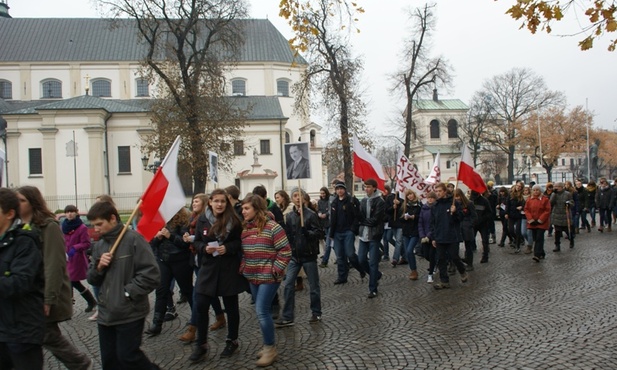 Pijarska młodzież podczas marszu niosła flagi i portrety polskich patriotów