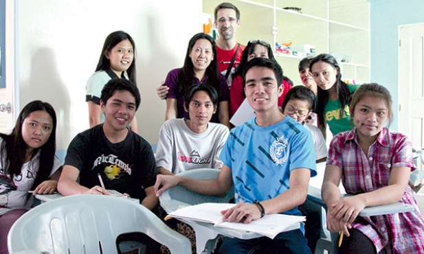   Ksiądz Artur (w środku w okularach) z nauczycielami i uczniami jednej ze swoich szkół