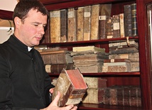 Ks. dr Grzegorz Klaja  przy starych księgach przekazanych muzeum w depozyt 