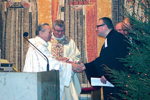  Bp Gerard Kusz i ks. Krzysztof Kłusek, proboszcz gliwickiej parafii ewangelicko-metodystycznej, przekazują sobie znak pokoju