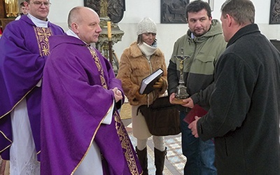  Proboszcz ks. Krzysztof Katana przekazał parafianom krzyż,  który będzie nawiedzał ich domy, oraz kronikę i modlitewniki