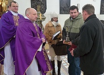  Proboszcz ks. Krzysztof Katana przekazał parafianom krzyż,  który będzie nawiedzał ich domy, oraz kronikę i modlitewniki