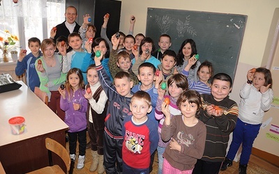 Uczniowie prezentują kroszonki wykonane na warsztatach z ks. Piotrem Herokiem