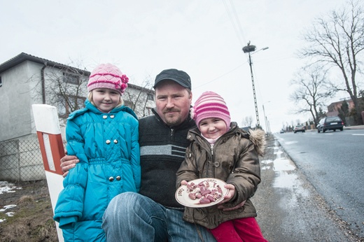 Sołtys Piątku Józef Stawiński  razem z córkami dokarmia  bociany