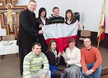  Do zakupu flag zachęcają młodzi wraz z asystentem kościelnym  KSM ks. Leszkiem Domagałą