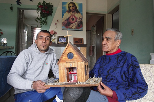 Gerardo Medina trzyma wraz z przybranym ojcem Arielem zrobioną przez siebie  miniaturę kapliczki