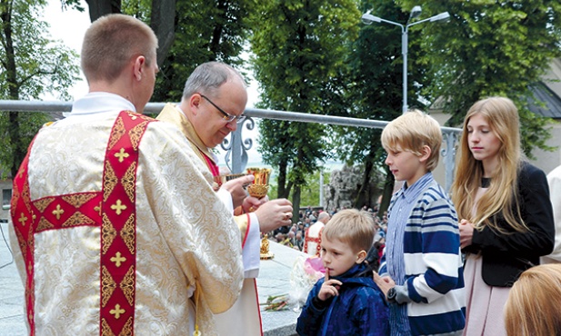W dniu święceń dk. Czesław Cebulla służy bp. Andrzejowi udzielającemu Komunii św. 