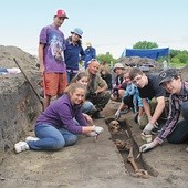  – Ten szkielet datuje się na koniec osiemnastego, początek dziewiętnastego wieku – mówi uczniom Letniej Szkoły Archeologii Maciej Trzeciecki (kuca trzeci z lewej). Stoi Barbara Fuglewicz