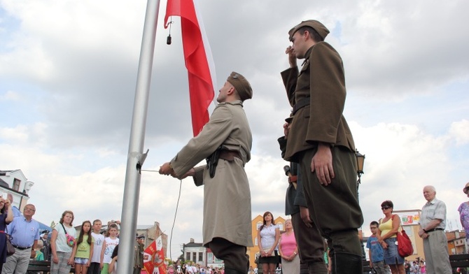 Flagę na maszt wciągają członkowie Muzealnej Grupy Rekonstrukcji Historycznej II Batalionu 18 Pułku Piechoty