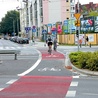  Pas rowerowy na jezdni – jeden cyklista jedzie prawidłowo, zgodnie z namalowaną strzałką, drugi – pod prąd 