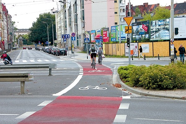  Pas rowerowy na jezdni – jeden cyklista jedzie prawidłowo, zgodnie z namalowaną strzałką, drugi – pod prąd 