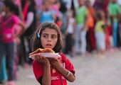 3.09.2013. Irak. Ebril. Dziewczynka z obozu Quru Gusik dla uchodźców z Syrii niesie jedzenie dla swojej rodziny. Według ONZ liczba osób, które opuściły swoje domy z powodu konfliktu, wzrosła do 6,25 miliona.  To największa grupa uchodźców na świecie. Około 168 tys. schroniło się w Iraku. 