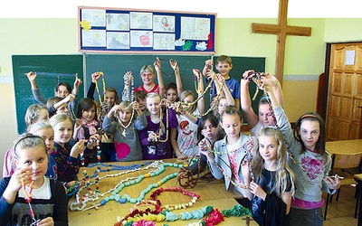 Katechetka Katarzyna Milczarek i uczniowie z SP 4 w Łowiczu z różańcami wykonanymi przez dzieci 