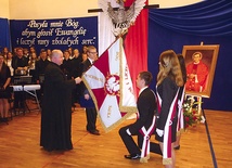  Dyrektor szkół ks. Tomasz Orzeł przekazuje uczniom sztandar szkoły