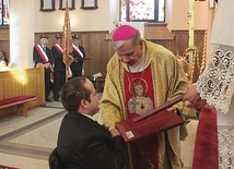  Łukasz Warzecha przyjmuje podziękowania od bp. Jana Kopca za wspieranie inwestycji ofiarą, modlitwą i niesieniem osobistego krzyża 