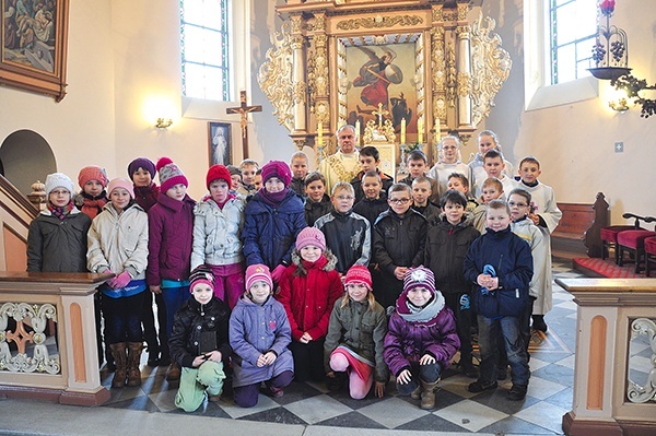 Proboszcz ks. Lucjan Gembczyk z młodymi parafianami  po Mszy szkolnej