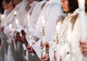 Po chrzcielnym obmyciu kandydaci zakładają alby i trwają ze świecami w ręku