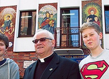 Z ks. Janem Gondro pod charakterystycznymi mozaikami u wejścia do szkoły 
