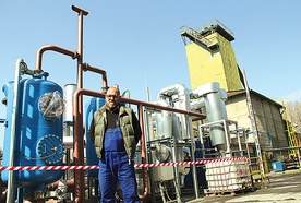   Dr inż. Piotr Mocek z GIG przed instalacją, którą płynie gaz z zapalonego pod ziemią węgla. W tle Szyb Wschodni KWK „Wieczorek”