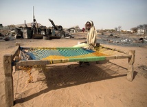  6.04.2014. Sudan. Dziewczyna siedzi na łóżku obok zgliszcz swego spalonego domu. Ponad 3 tys. mieszkańców Darfuru musiało opuścić swoje domy 22 marca br. po ataku zbrojnej grupy