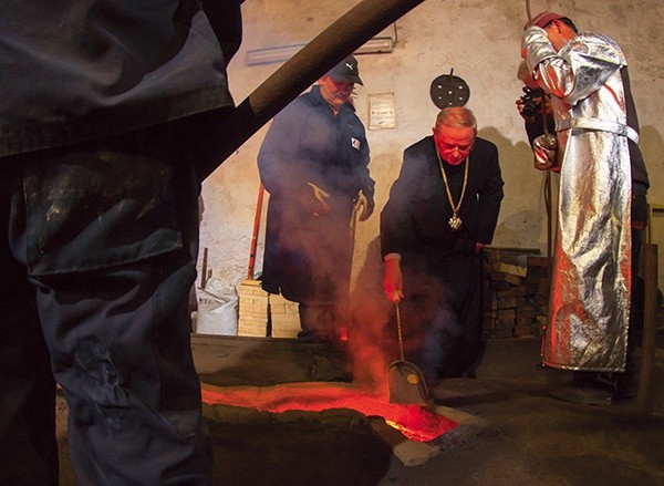 Ks. Zdzisław Sochacki wrzuca do płynącego rynienką stopu złoty medal Jana Pawła II