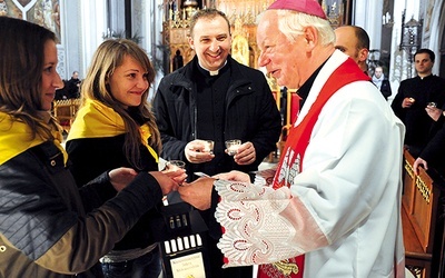 Powyżej: Jako pierwszy w radomskiej katedrze wypełnionej wiernymi, w większości młodzieżą, lampion od stypendystów otrzymał bp Adam Odzimek 