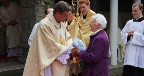 Sabina Martynowicz wręcza bp. Romanowi Pindlowi pakiet pielgrzyma