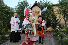 Bp Józef Zawitkowski i ks. Adam Domański oraz dzieci w strojach łowickich przy kapliczce Matki Bożej Księżnej Łowickiej