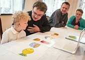 Ks. Piotr Grzesik przygotowuje Karolka do jego Pierwszej Komunii św. Z prawej strony – rodzice Karolka, Anna i Zbigniew Kasprzykowie