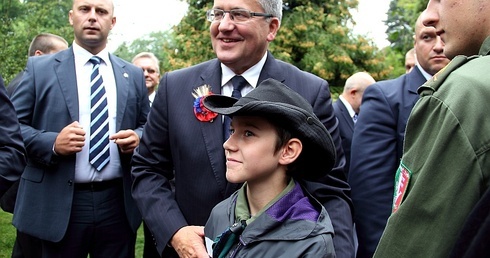 Prezydent Komorowski pozuje do zdjęcia z młodym harcerzem