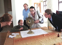  Uczestnicy spotkania muzealnego przyglądają się hałcnowskiej monstrancji z XIX wieku