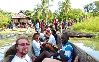  Misjonarz (na pierwszym planie) dopływa do wioski na rzece Sepik