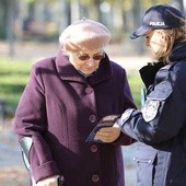 Policjantka ostrzega kobietę przed oszustami