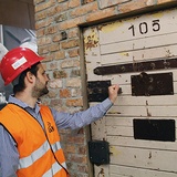Dr Konrad Knoch, kierownik Działu Wystawy Stałej ECS, pokazuje drzwi aresztu śledczego, będącego częścią ekspozycji poświęconej represjom politycznym