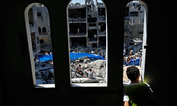  21.08.2014, strefa gazy. Palestyńska młodzież na gruzach domów zniszczonych przez izraelskie odrzutowce w mieście Rafah, w południowej Strefie Gazy.
